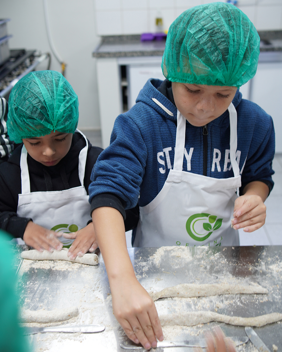 Criança com mão na massa colocando em prática os conhecimentos recebidos pelo projeto Oficina Saudavel da Cancian Refeições