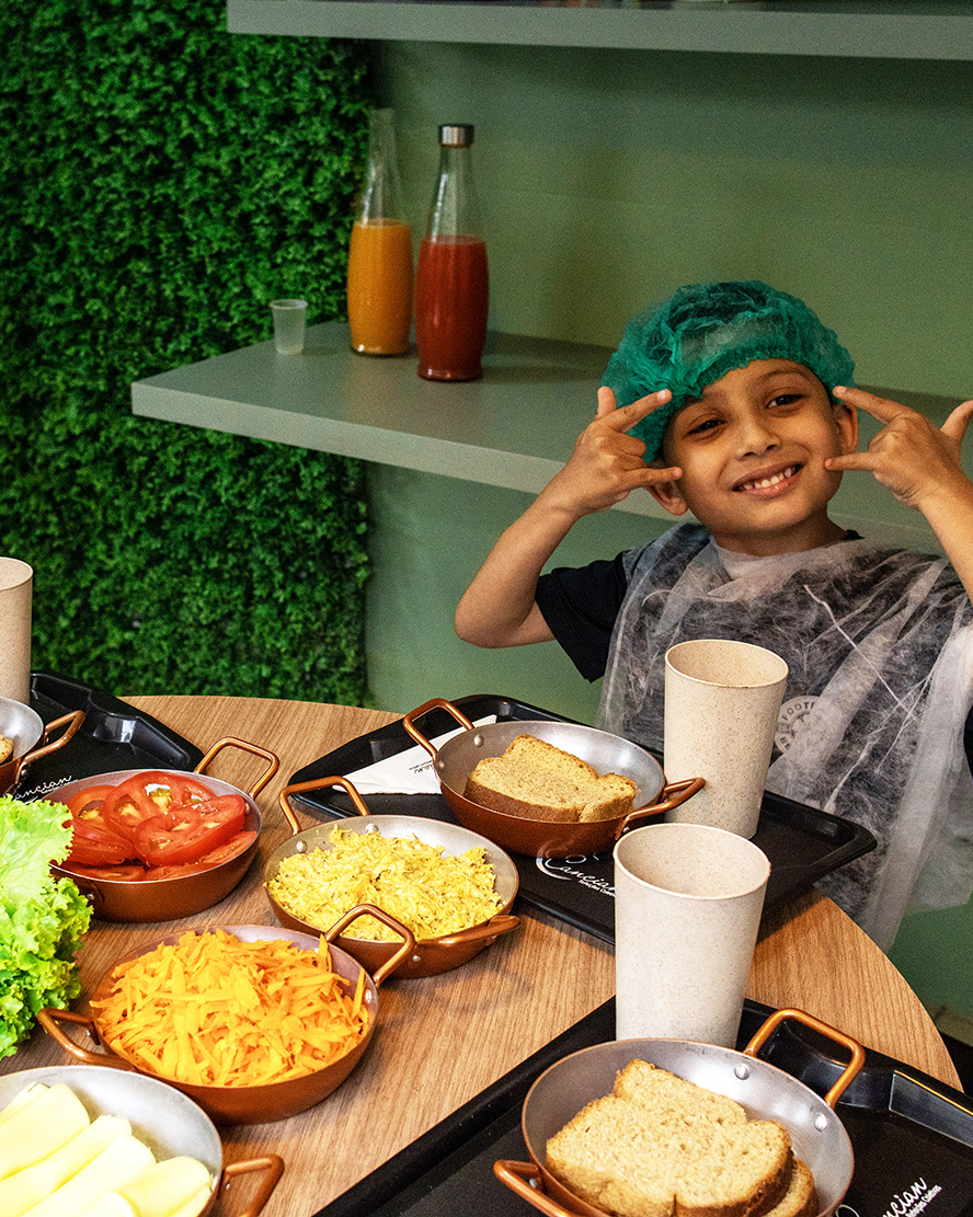 Criança feliz com alimentos saudáveis em projeto Oficina Saudavel da Cancian Refeições